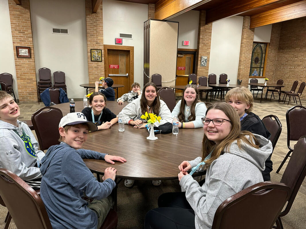 Confirmation students smiling around a table